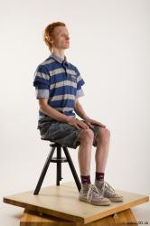 Sitting reference of whole body striped blue gray shirt blue jeans shorts black gray shoes Wesley